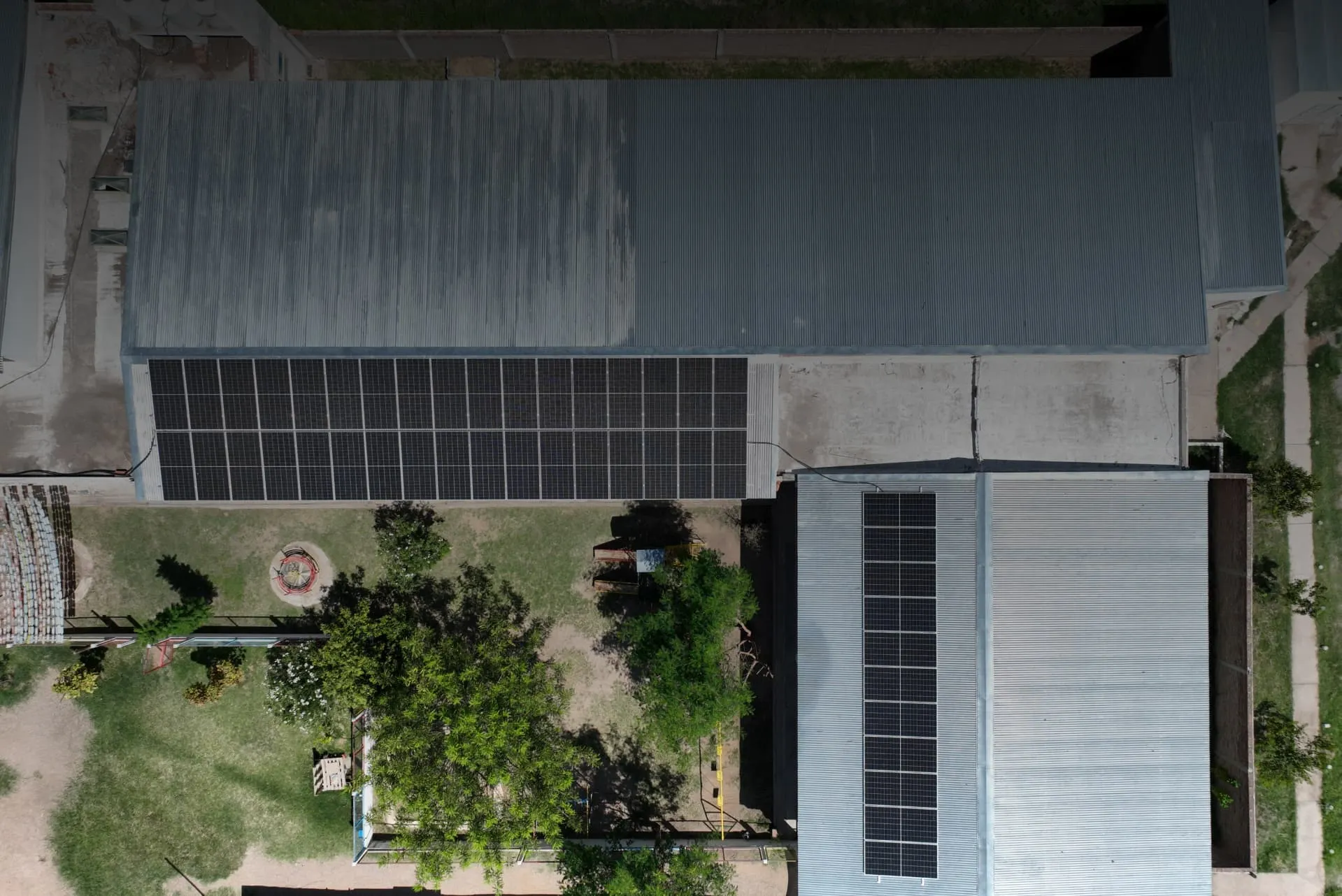 Vista aérea de dos naves con paneles solares instalados sobre sus techos