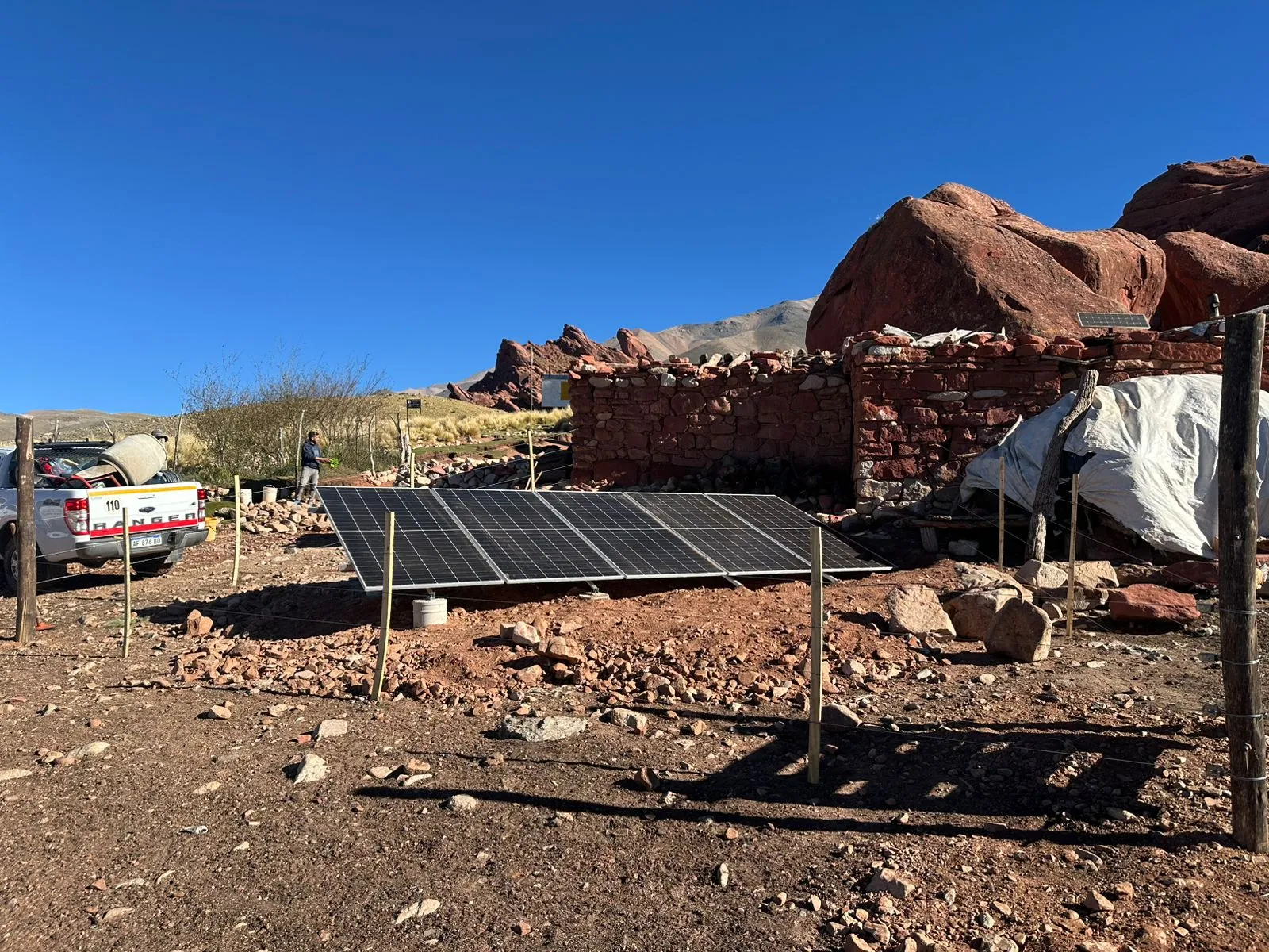 Panel solar autónomo montado en el suelo junto a un puesto rural de montaña
